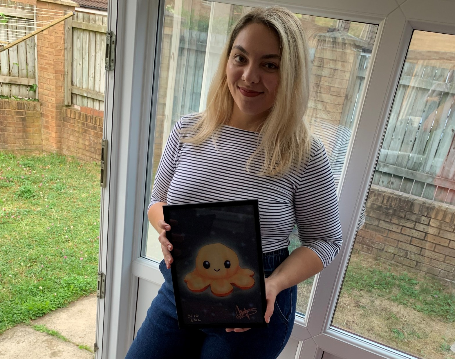 Photograph of Diana Ionita with Happy Boy artwork by Ellie Chapman